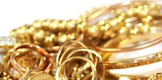 Gold slips from two-week peak as dollar ticks up Gold